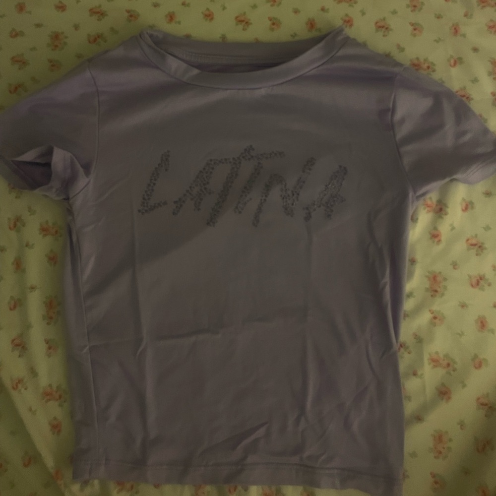 Cute Top in color purple size xs. The words spell out LATINA